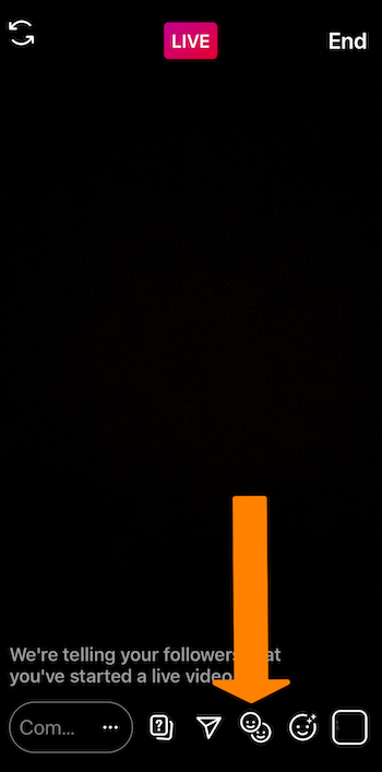 स्क्रीन के नीचे स्माइली चेहरे के आइकन की ओर इशारा करते हुए एक नारंगी तीर के साथ एक इंस्टाग्राम लाइव प्रसारण का स्क्रीनशॉट