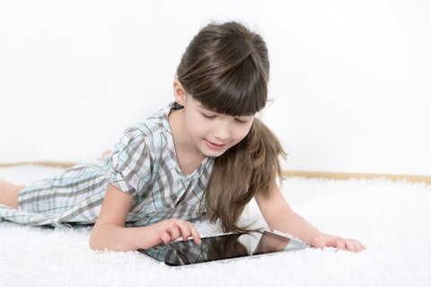 स्टॉक फोटो 23514521 छोटी लड़की एक टैबलेट के साथ खेल रही है