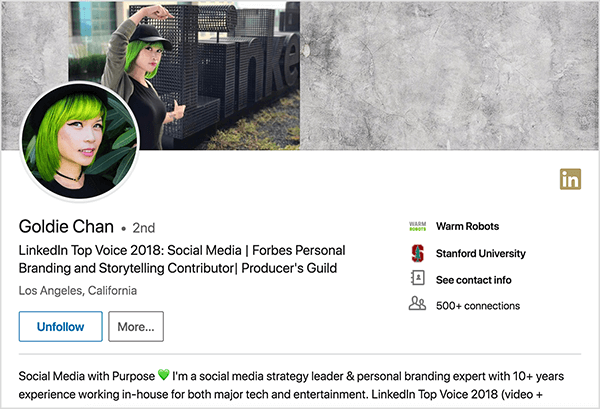 यह गोल्डी चान के लिंक्डइन प्रोफाइल का स्क्रीनशॉट है। वह हरे बालों वाली एक एशियाई महिला है। उसके प्रोफाइल फोटो में, उसने एक मेकअप, एक काले रंग का गला और एक काली शर्ट पहनी हुई है। उसकी टैगलाइन कहती है “लिंक्डइन टॉप वॉयस 2018: सोशल मीडिया | फोर्ब्स पर्सनल ब्रांडिंग और स्टोरीटेलिंग कंट्रीब्यूटर | निर्माता का गिल्ड ”